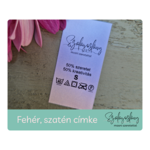 Fehér szatén nyomott, bevarrható címke. Logóval, anyagösszetétellel, kezelési utasítással nyomtatva. Szalagoslány, Lévay Nóra