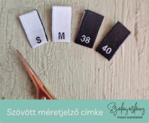 Szövött címke, szövött méretjelző, fehér és fekete alapon, darabolva, hajtogatva
